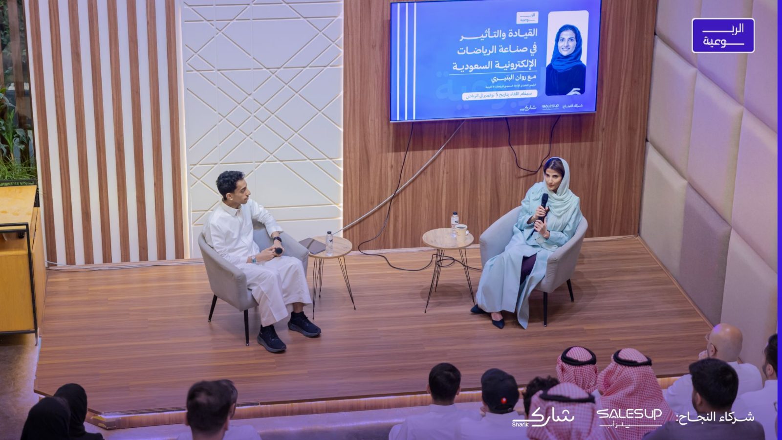 روان البتيري تتحدث بالمايكروفون خلال لقاء الربوعية